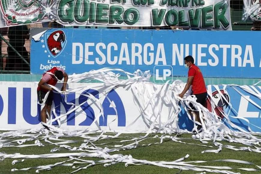 Utileros del Marathón recogiendo el papel que lanzaron los aficionados verdolagas previo al partido contra el Motagua.