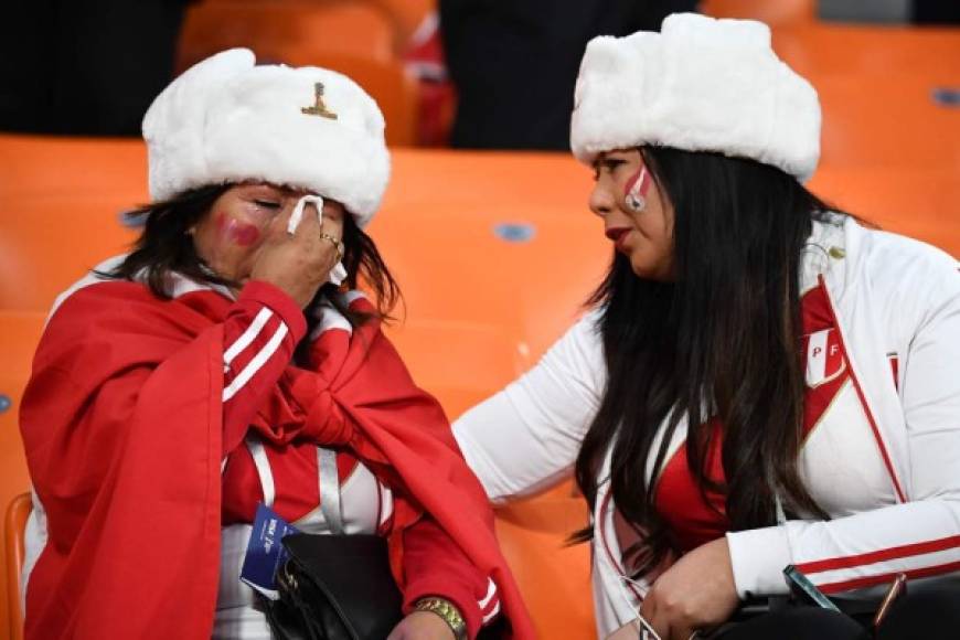 Una aficionada peruana consuela a otra hincha que llora por la eliminación de Perú. Foto AFP