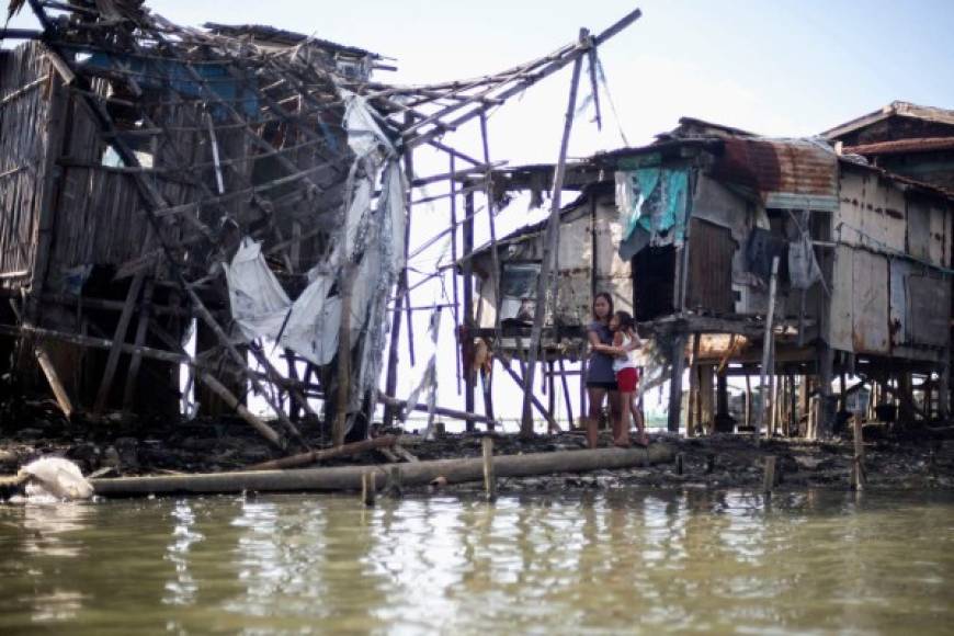 This photo taken on January 11, 2019 shows residents looking out onto the bay waters in Sitio Pariahan, Bulacan. - Areas north of Manila like the provinces of Pampanga and Bulacan have sunk four-six centimetres (1.5-2.4 inches) a year since 2003, according to satellite monitoring. The creeping bay waters put people and property at risk, while the threat is amplified by high-tides and flooding brought by the roughly 20 storms that pound the archipelago every year. (Photo by Noel CELIS / AFP) / TO GO WITH Philippines-water-climate,FEATURE by Joshua MELVIN