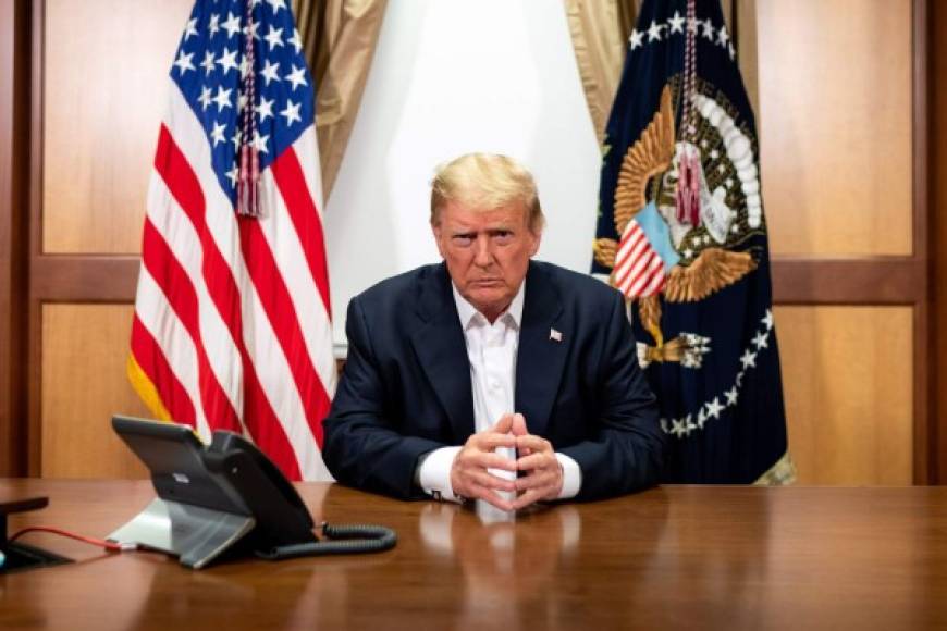 TOPSHOT - This handout photo released by the White House shows US President Donald Trump and his Chief of Staff (not pictured) participating in a phone call with the US Vice President, Secretary of State and Chairman of the Joint Chiefs of Staff on October 4, 2020, in his conference room at Walter Reed National Military Medical Center in Bethesda, Maryland. - President Donald Trump has 'continued to improve' as he is treated for Covid-19 at a military hospital near Washington, his doctors said October 4, adding that he could be discharged as early as October 5. (Photo by Tia DUFOUR / The White House / AFP) / RESTRICTED TO EDITORIAL USE - MANDATORY CREDIT 'AFP PHOTO / THE WHITE HOUSE / TIA DUFOUR ' - NO MARKETING - NO ADVERTISING CAMPAIGNS - DISTRIBUTED AS A SERVICE TO CLIENTS