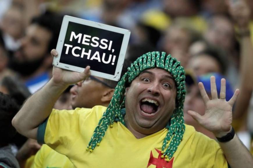 Un aficionado brasileño se burla de Messi con una tarjeta que dice 'Messi adiós' al final del partido Brasil-Argentina.