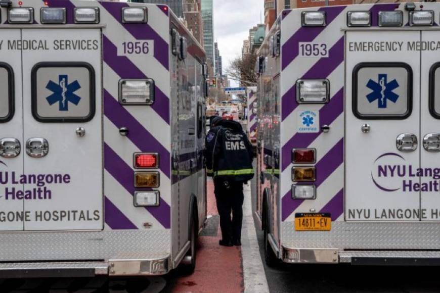 Un trabajador entre dos ambulancias estacionadas al costado de la sala de emergencias en la NYU Langone Heath de la ciudad de Nueva York. AFP