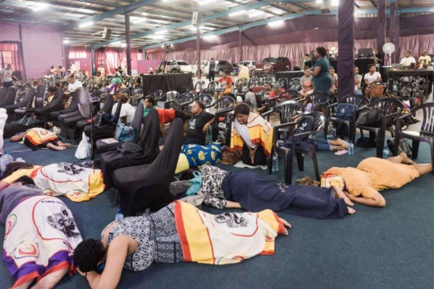 Los fieles de la Iglesia del Mandato de Nala prestan atención al llamado a rezar bajo el tema 'Oración del orden de restricción divina contra el virus de la Corona' por el Rey Somnala, jefe de la Iglesia del Mandato de Nala, en Durban. Foto AFP