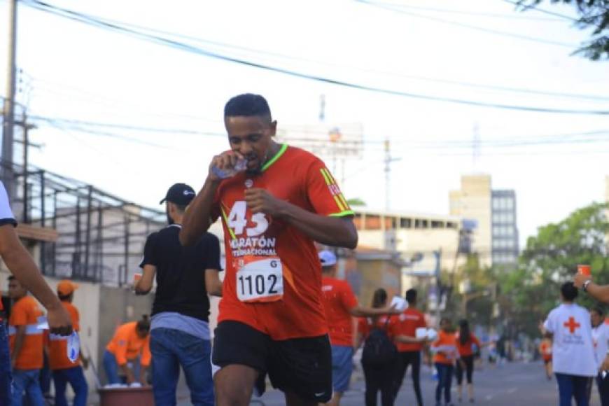 Uno de los participantes hidratándose mientras realiza su recorrido en la maratón.