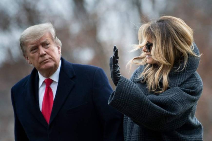 US President Donald Trump and First Lady Melania Trump walk from Marine One as they return to the White House on December 31, 2020, in Washington, DC. (Photo by Brendan Smialowski / AFP)
