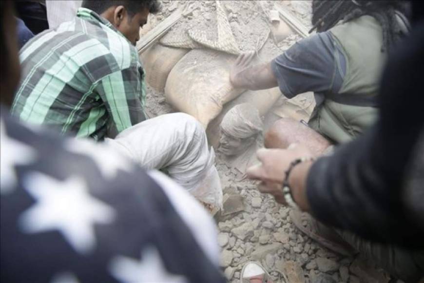 Varias personas luchan por sacar a un hombre enterrado entre los escombros tras un terremoto en Katmandú (Nepal) hoy, sábado 25 de abril de 2015. EFE