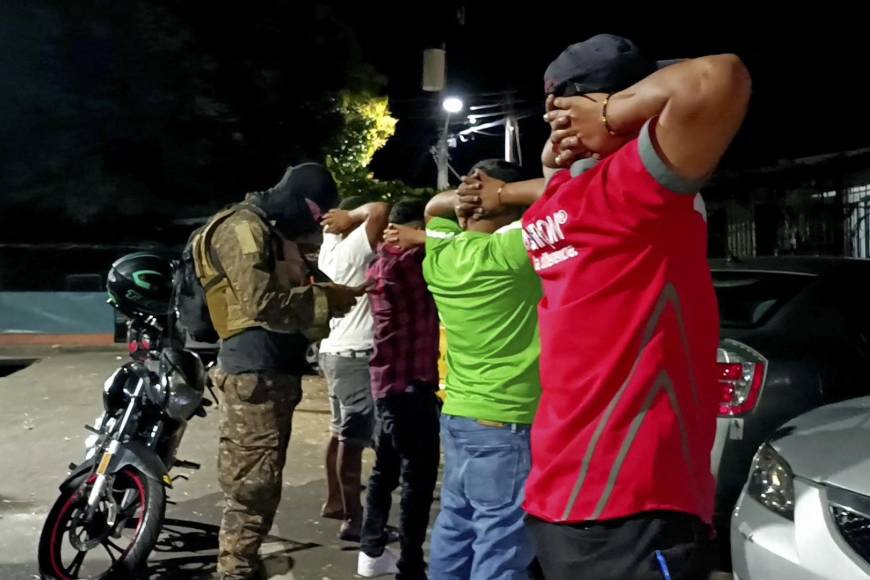 This screen grab obtained from a handout video released by El Salvador's Presidency press office shows a soldier checking the identity of men during an operation searching for gang members in Soyapango, El Salvador, on December 3, 2022. - Nearly 10,000 military and police officers surrounded the populous municipality of Soyapango, on the outskirts of San Salvador, early Saturday morning as part of the war against gangs launched in March by Salvadoran President Nayib Bukele. (Photo by Handout / EL SALVADOR'S PRESIDENCY PRESS OFFICE / AFP) / RESTRICTED TO EDITORIAL USE - MANDATORY CREDIT "AFP PHOTO / EL SALVADOR'S PRESIDENCY PRESS OFFICE " - NO MARKETING - NO ADVERTISING CAMPAIGNS - DISTRIBUTED AS A SERVICE TO CLIENTS