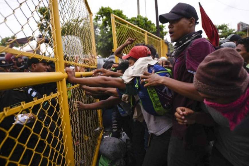 Guatemalan security forces try to prevent Honduran migrants from reaching the Guatemala-Mexico international border bridge in Ciudad Tecun Uman, Guatemala, on October 28, 2018. - A new group of Honduran migrants is trying to reach and cross the Guatemalan border into Mexico in the hope of eventually realizing the 'American dream' and reaching the United States. (Photo by SANTIAGO BILLY / AFP)