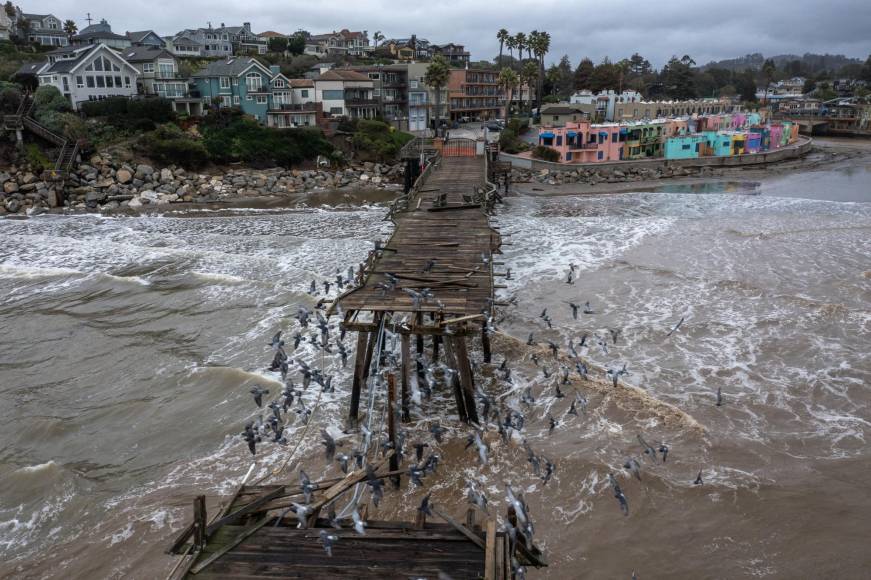 This aerial view shows the Capitola Pier, built in 1857, damaged after recent storms in Capitola, California, on January 15, 2023. - Soggy Californians on Sunday wearily endured their ninth successive storm in a three-week period that has brought destructive flooding, heavy snowfalls and at least 19 deaths, and forecasters said more of the same loomed for another day. (Photo by DAVID MCNEW / AFP)
