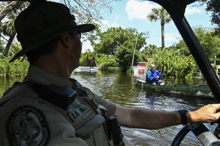 El teniente James Brodbeck (L) de Florida Fish and Wildlife Conservation patrulla el vecindario inundado después de fuertes lluvias en Fort Lauderdale, Florida. 