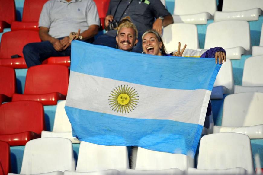 Gastón y Jasmín ya adentro del estadio Nacional Chelato Uclés posando con una bandera de Argentina.