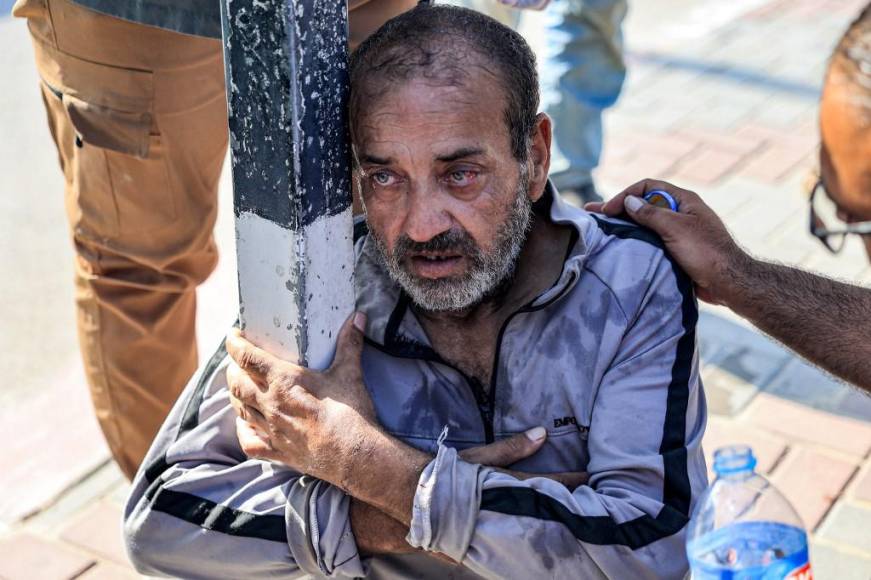  Uno de los trabajadores palestinos que quedó varado en Israel desde los ataques del 7 de octubre recibe asistencia después de que se desplomara al llegar al cruce fronterizo de Rafah con Egipto tras cruzar a la Franja de Gaza.