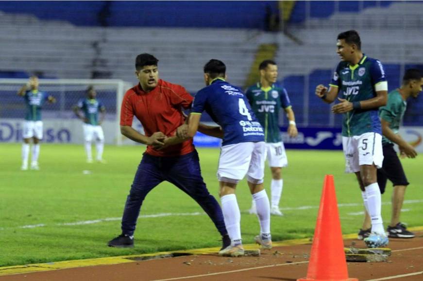 Francisco Martínez tratando de controlar a este otro aficionado en la pista del estadio Olímpico.