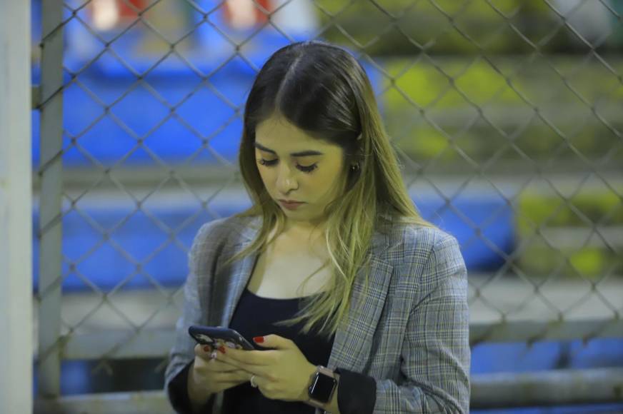 ¿A quién le estaba escribiendo? La periodista Karla López fue captada revisando su celular antes del inicio del juego.
