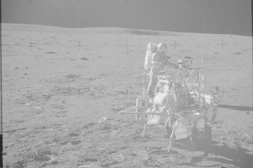 Un astronauta de la misión Apolo 14 instala un aparato sobre la superficie de la luna.