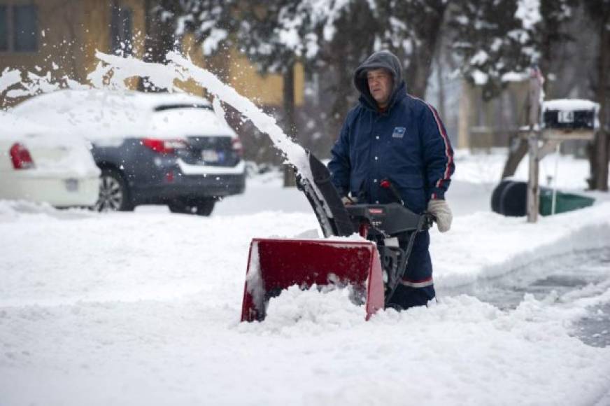 A man in a US postal uniform uses a snow blower to clear a street during Winter Storm Harper in Saugus, Massachusetts on January 20, 2019. (Photo by Joseph PREZIOSO / AFP)