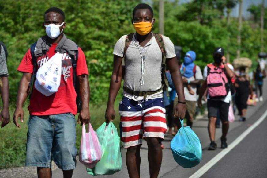 Members of a caravan of migrants from DR Congo, Ghana and Ivory Coast head along the Pan-American highway near Choluteca, in Honduras, to the capital Tegucigalpa for a stop on their way to Mexico, on June 2, 2020 amid the Covid-19 coronavirus pandemic. (Photo by Orlando SIERRA / AFP)