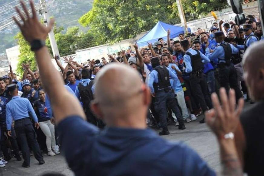 El miembro de seguridad privada del Motagua pidiendo calma a los aficionados motagüenses que lanzaban latas de cervezas a los jugadores del Olimpia.