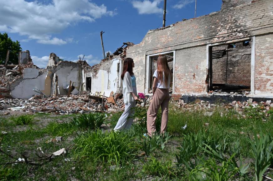 Desafiantes estudiantes ucranianos celebran su fiesta de graduación frente a las ruinas de su escuela