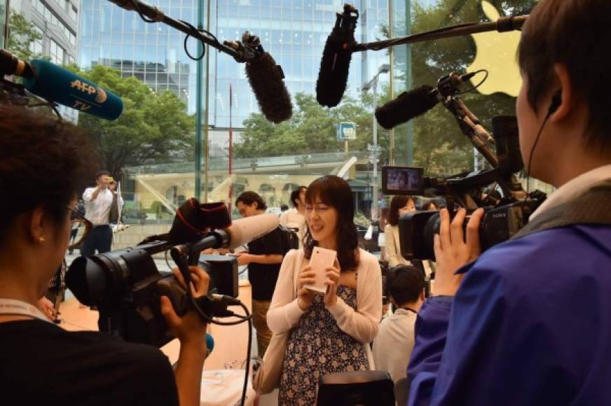 Los medios de comunicación entrevistan a una compradora de iPhone en Tokio, Japón.