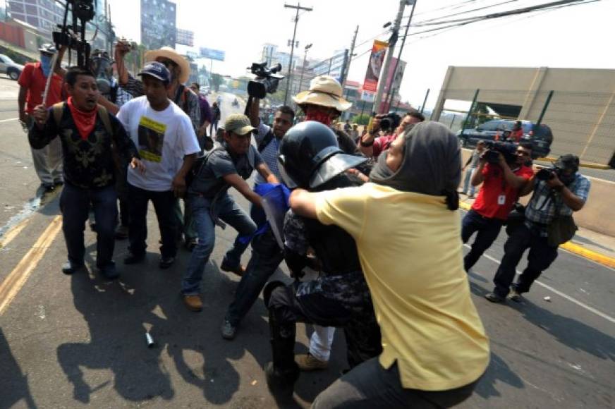 Indígenas lencas del Copinh se enfrentaron con policías antimotines frente a Casa Presidencial en Tegucigalpa. AFP