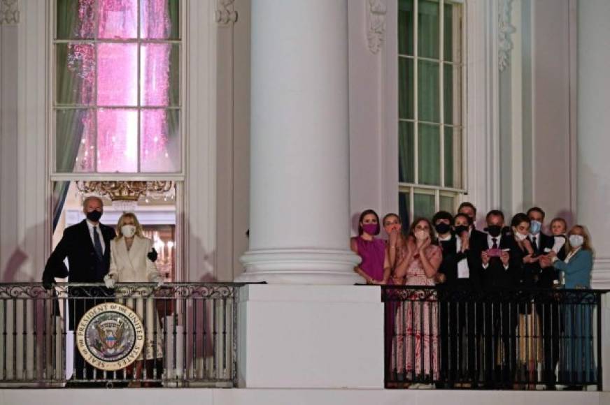 TOPSHOT - US President Joe Biden (L) and First Lady Jill Biden (2nd L) appear on the Blue Room Balcony as they and family members (R) watch fireworks from the White House in Washington, DC on January 20, 2021. (Photo by JIM WATSON / AFP)