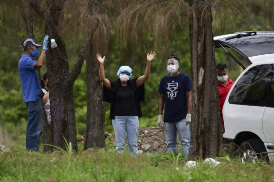 Familiares y amigos rezan durante el entierro de una víctima de COVID-19 en el cementerio Parque Memorial Jardín de Los Ángeles. AFP