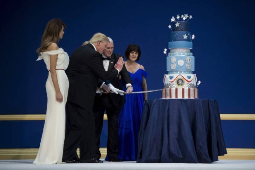 La primera dama estadounidense, Melania Trump y Karen Pence, observan cómo el vicepresidente estadounidense Mike Pence y el presidente de los Estados Unidos, Donald Trump, cortaron un pastel con una espada durante la Bola de Servicios Armados.