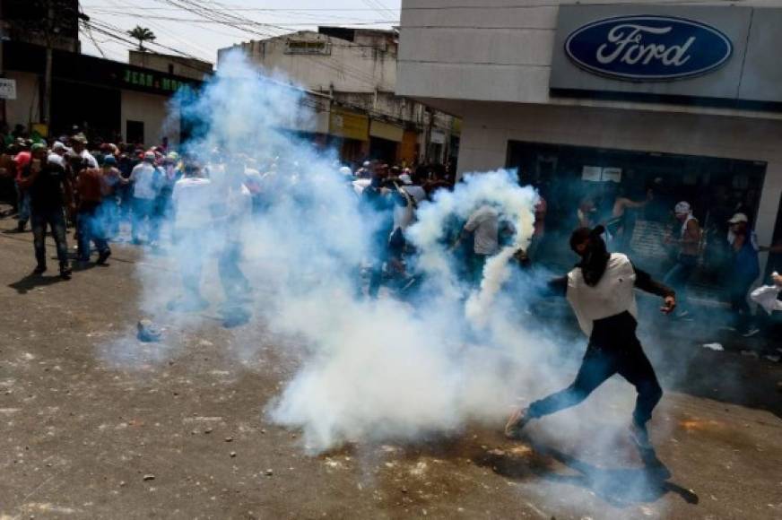 La mayoría de los manifestantes, algunos encapuchados, retrocedían cuando caían los gases y posteriormente volvían a la carga contra la treintena de policías venezolanos que defendían la línea divisoria entre ambas naciones.