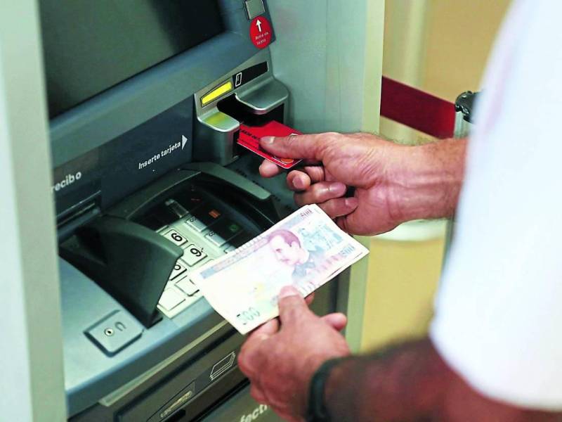 Un ciudadano retira dinero de un cajero automático.