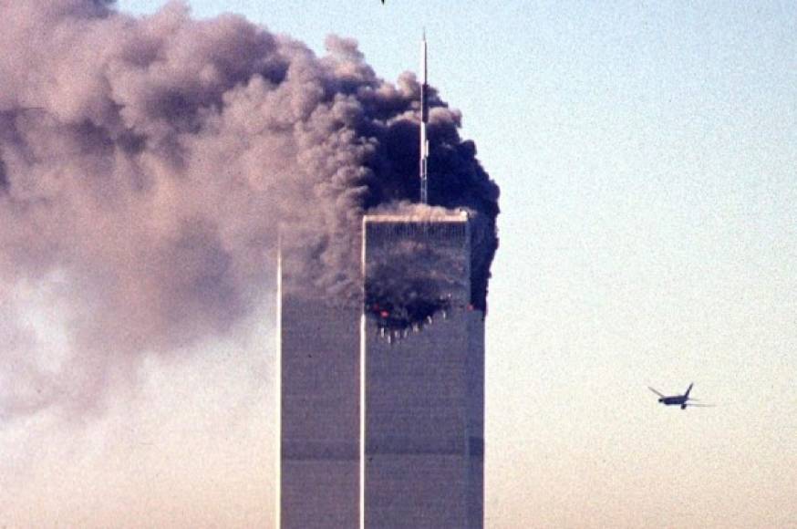 "(FILES) In this file photo taken on September 11, 2001, a hijacked commercial aircraft approaches the twin towers of the World Trade Center shortly before crashing into the landmark skyscraper in New York. - The remains of two more victims of 9/11 have been identified, thanks to advanced DNA technology, New York officials announced on September 8, 2021, just days before the 20th anniversary of the attacks. The office of the city's chief medical examiner said it had formally identified the 1,646th and 1,647th victim of the al-Qaeda attacks on New York's Twin Towers which killed 2,753 people. They are the first identifications of victims from the collapse of the World Trade Center since October 2019. (Photo by SETH MCALLISTER / AFP)"