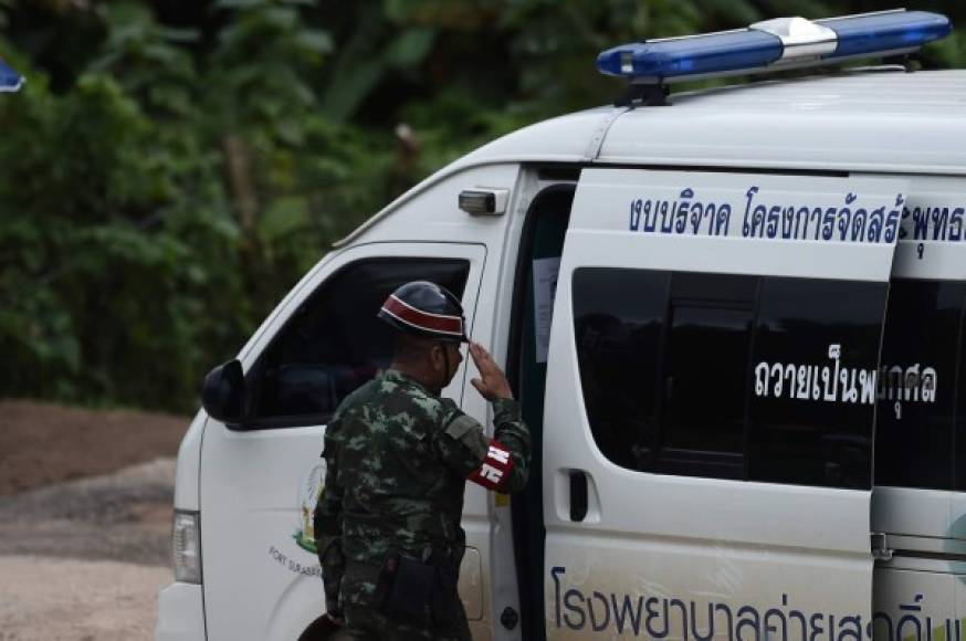 A Thai military police salutes an ambulance leaving from the Tham Luang cave area as the operations continue for those still trapped inside the cave in Khun Nam Nang Non Forest Park in the Mae Sai district of Chiang Rai province on July 10, 2018.<br/>Rescuers raced to save four young footballers and their coach who remain trapped in a flooded Thai cave on July 10, as heavy rains threatened an already perilous escape mission that has seen eight of the boys extracted in 'good health'. / AFP PHOTO / YE AUNG THU