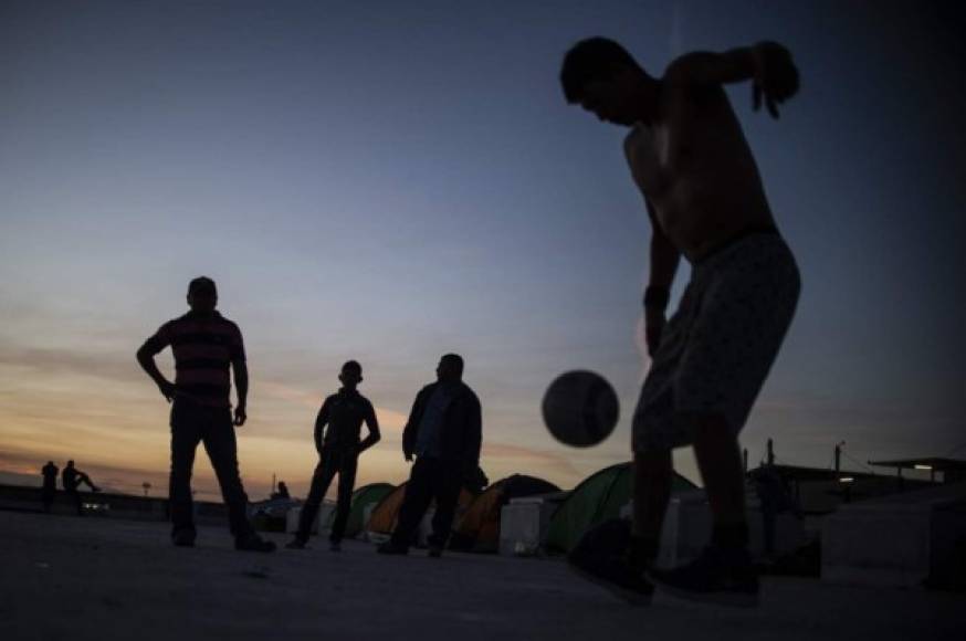 Los migrantes más jóvenes matan el tiempo jugando fútbol en las playas de Tijuana. Las autoridades mexicanas estiman que los miembros de la caravana se verán obligados a acampar por varios meses antes de que las autoridades estadounidenses definan sus casos.