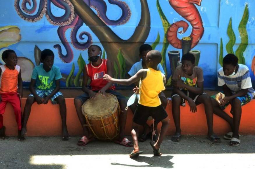 Niños garífunas tocan y bailan punta en Tela durante el fin de semana cuando las autoridades han autorizado que el fin de semana pueden circular las personas con salvoconducto de turismo.