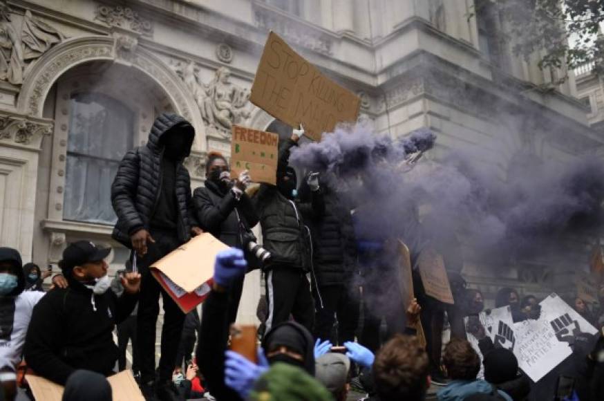 Los manifestantes sostienen pancartas mientras asisten a una manifestación en Whitehall, cerca de la entrada de Downing Street, en el centro de Londres. AFP