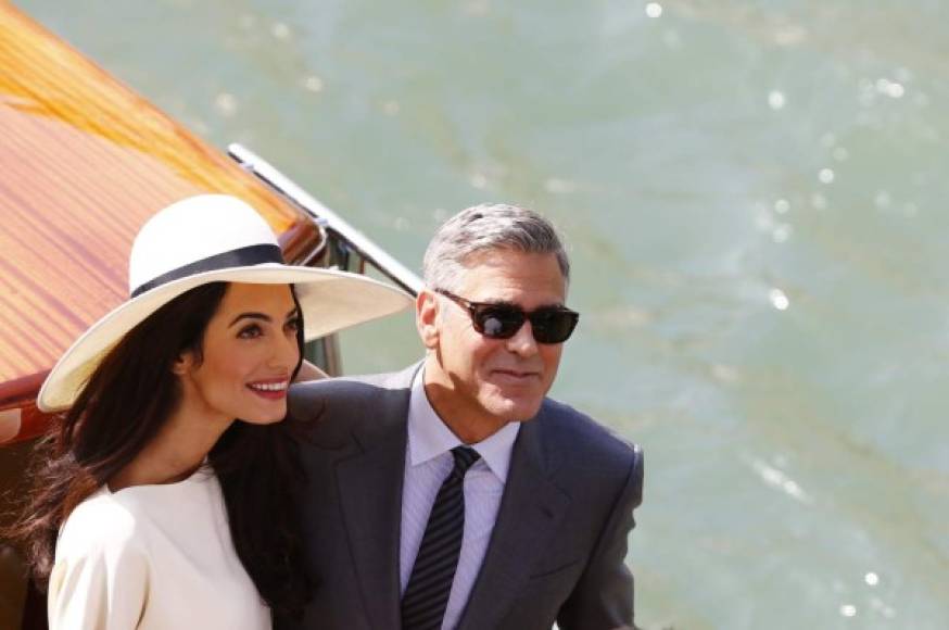 El actor George Clooney y su mujer, Amal Alamuddin, disfrutan de un paseo por las calles de Venecia de la mano este lunes, a su llegada al ayuntamiento de Venecia para hacer oficial su matrimonio. Ella, ya como mujer del actor, elige la pamela para su estilismo de Stella McCartney.