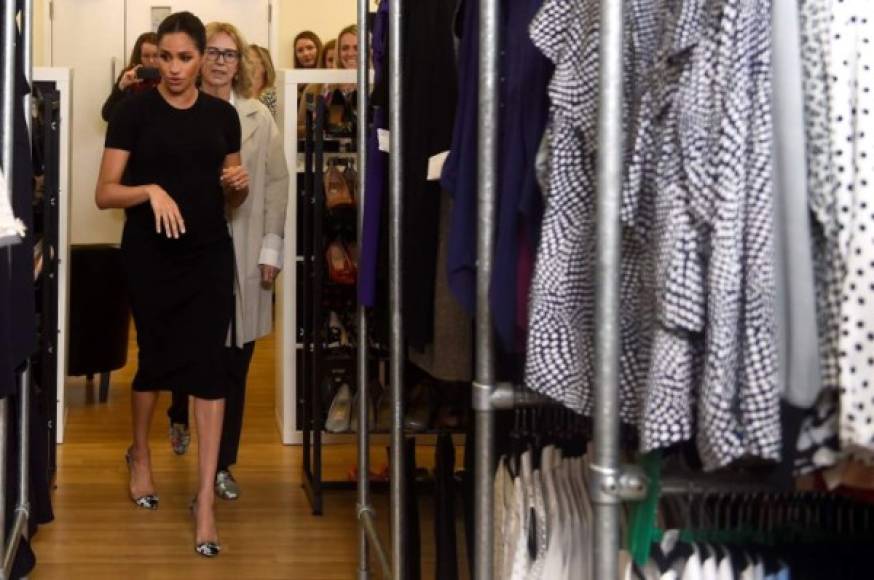 "Britain's Meghan, the Duchess of Sussex (L), walks through clothes racks with Chair of Smart Works Lady Juliet Hughes-Hallett (R) during her visit to Smart Works, a charity to which she has become patron, at St Charles hospital in west London on January 10, 2019. (Photo by CLODAGH KILCOYNE / POOL / AFP)"