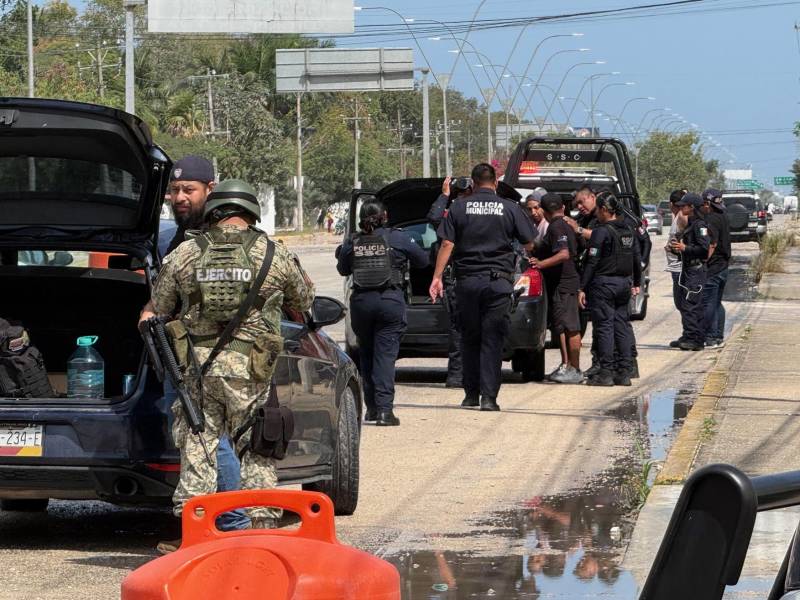 Integrantes del Ejército de México y policías estatales revisan vehículos este domingo, en el balneario de Cancún en Quintana Roo (México).