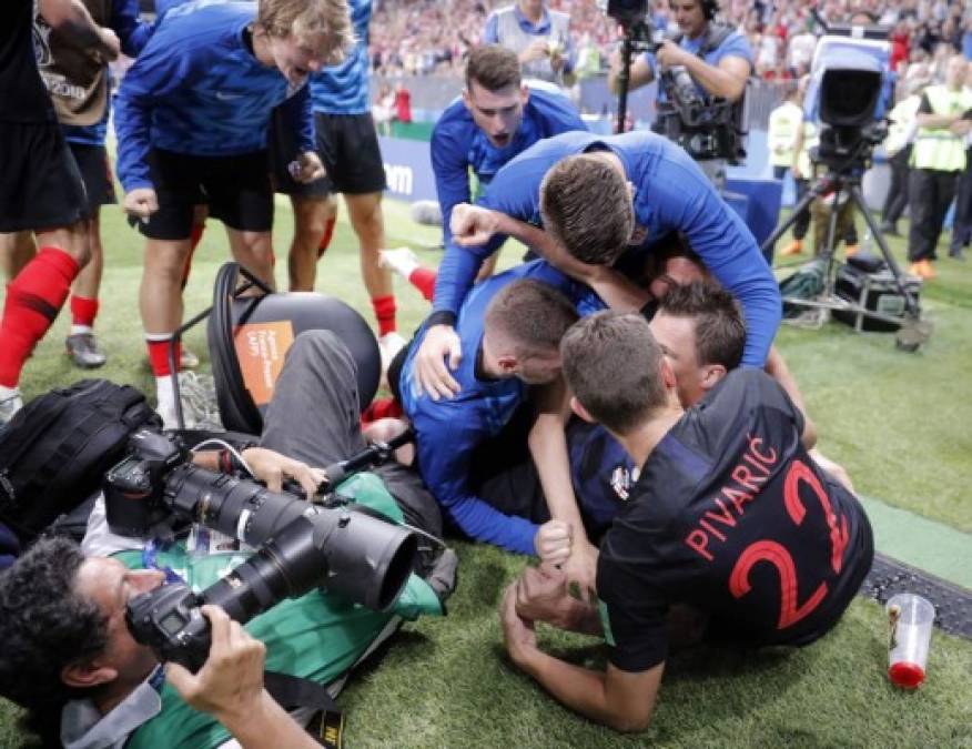 Futbolistas titulares y suplentes de Croacia formaron una montaña humana bajo la cual quedó el reportero gráfico Yuri Cortez. Foto EFE