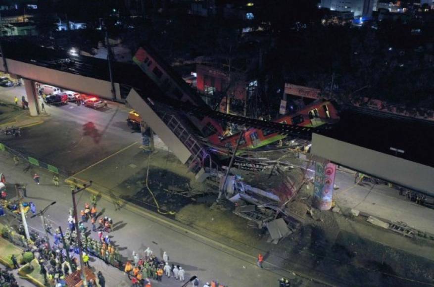 TOPSHOT - An aerial view shows rescue workers at the site of a metro train accident after an overpass for a metro partially collapsed in Mexico City on May 3, 2021. - At least 15 people were killed and dozens injured when an elevated metro line collapsed in the Mexican capital on May 3 as a train was passing, authorities said. (Photo by PEDRO PARDO / AFP)