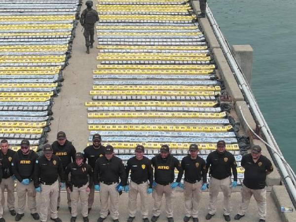 Agentes de la Atic posan con los paquetes de cocaína a sus espaldas.