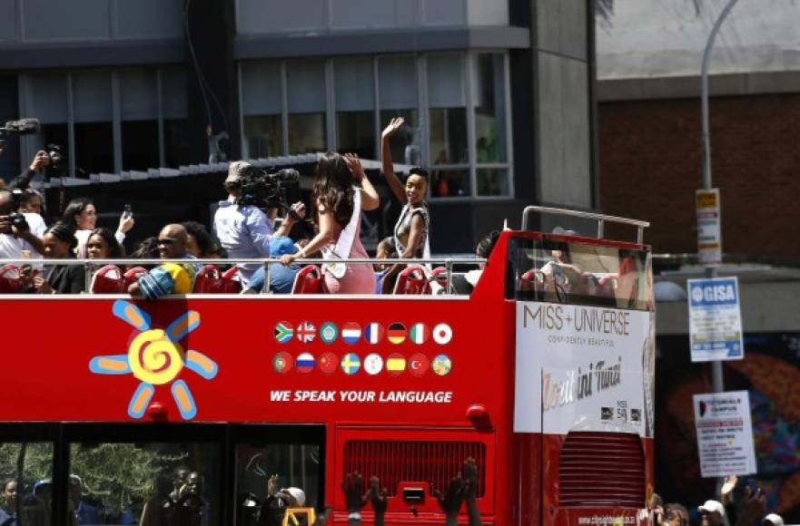 Zozibini Tunzi, con un corte de cabello natural, pendientes azules y un vestido con estampados africanos, saludó sonriendo a los espectadores desde un autobús sin techo en Johanesburgo.