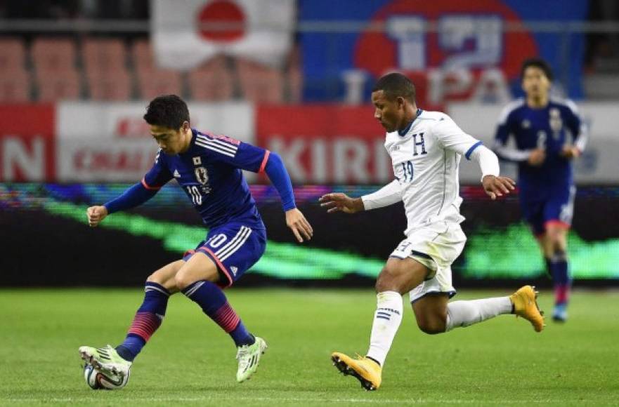 El centrocampista hondureño Luis Garrido sigue al japonés Shinji Kagawa durante el partido amistoso.