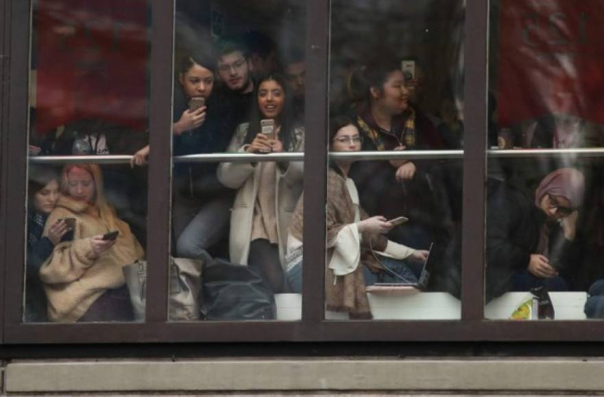 Los estudiantes esperan en una ventana mientras intentan vislumbrar a la duquesa de Sussex en su visita a la Asociación de Universidades del Commonwealth (ACU), en la City University de Londres este 31 de enero de 2019.<br/>