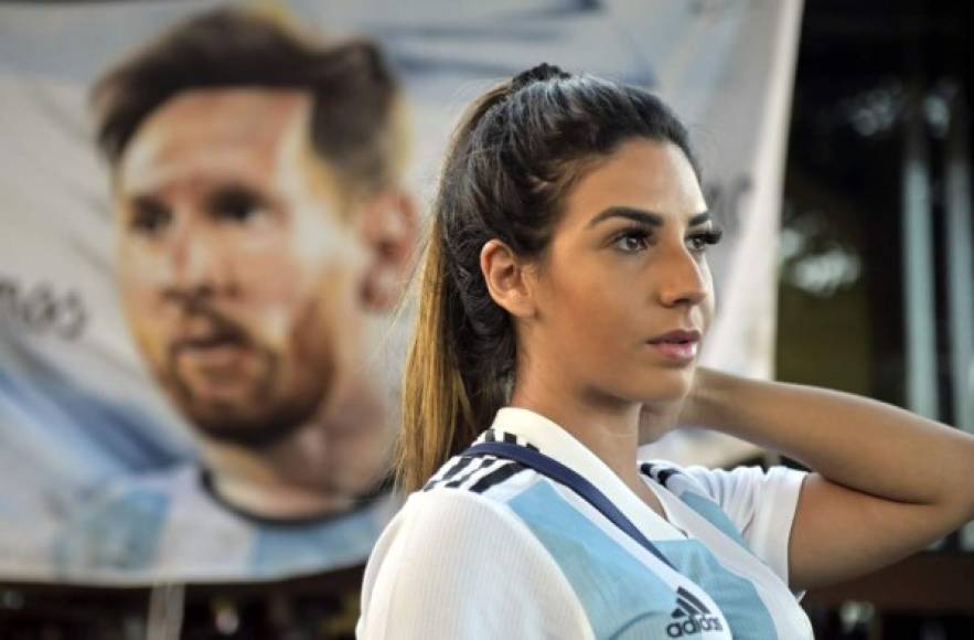 Otra bella aficionada argentina, con una imagen de Messi de fondo.