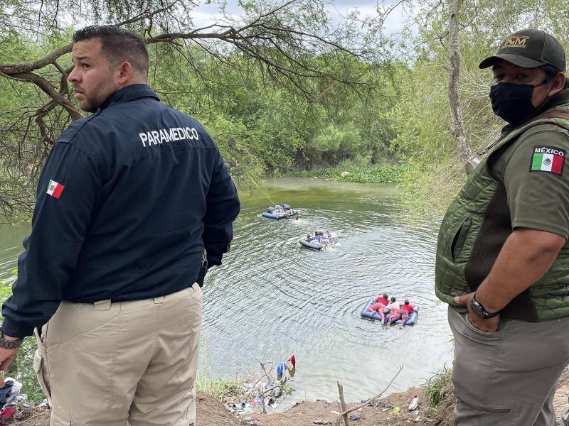 Migrantes centroamericanos se lanzan al Río Bravo para cruzar hacia Estados Unidos frente a agentes mexicanos.