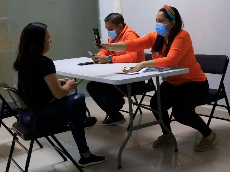 verificación. Una persona en el proceso de validación biométrica para luego entregarle su DNI.