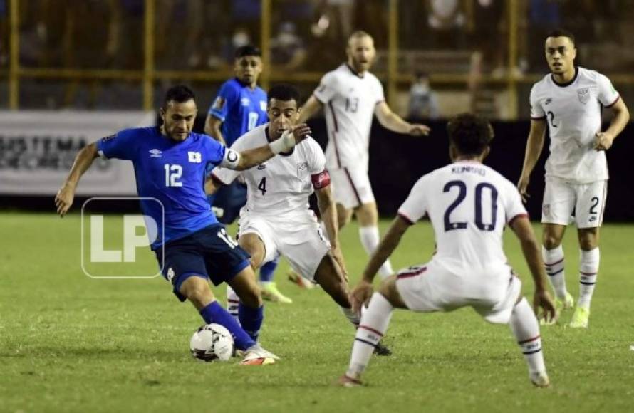 El capitán de El Salvador, Marvin Monterroza, es marcado por dos jugadores estadounidenses.