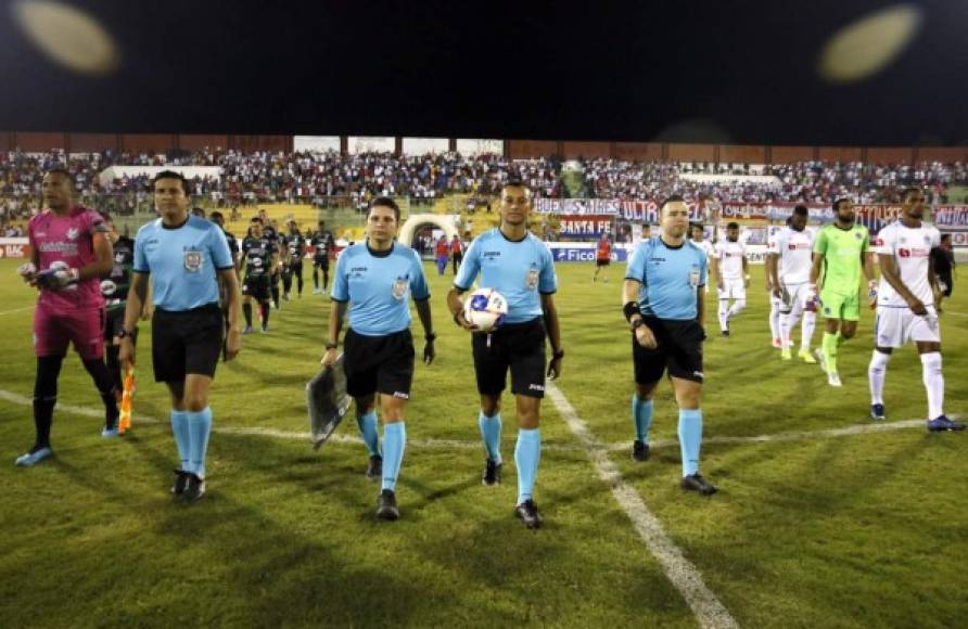 La salida de los equipos titulares de Olimpia y Platense, encabezados por la cuarteta arbitral.