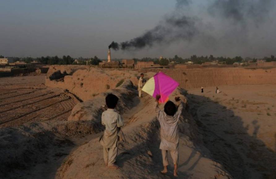 AFGANISTÁN. Tiempo para jugar. Dos niños afganos juegan con sus cometas al atardecer en Jalalabad. Foto: AFP/Noorullah Shirzada